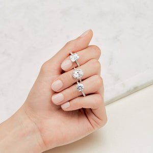 Hand with three different engagement ring styles